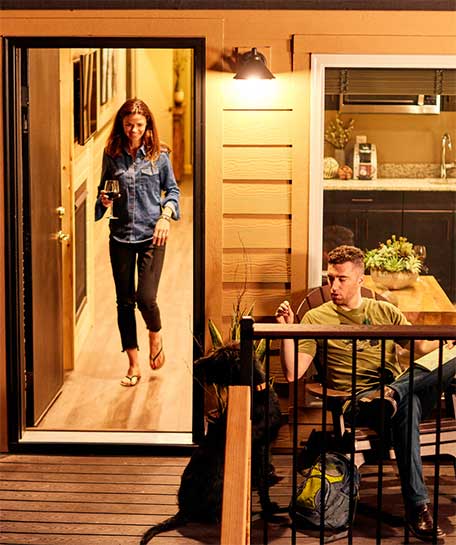 Couple enjoying an evening drink on the porch of their Explorer Cabin at Tenaya Lodge