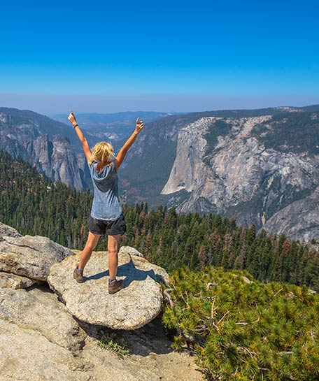Hiker on Sentinel Dome with a view of El Capitan and the Cathedrals