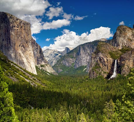 View of the Yosemite valley during a sunny afternoon with blue skies and puffy clouds