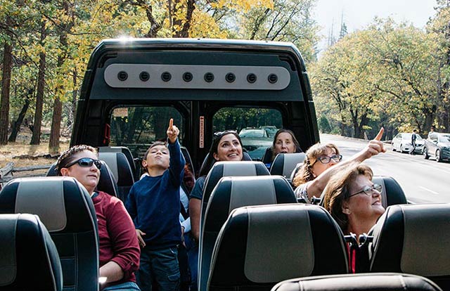 Happy passengers relaxing in a Tenaya Tours bus while the guide handles the driving